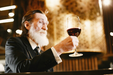 Elegant old man is resting in restaurant