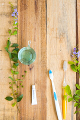 mouthwash, toothbrush health care for oral cavity with flowers arrangement flat lay style on background wooden