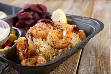 A closeup view of a shrimp kabob combo in a styrofoam to-go container.