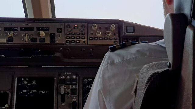 Pilot in the cockpit adjusting controls, flying plane