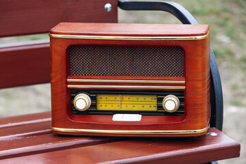 Retro radio receiver on bench outdoors, closeup