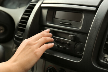 Woman tuning radio in car, closeup