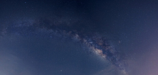 Naklejka na ściany i meble Panorama blue night sky milky way and star on dark background. Universe filled with stars, nebula and galaxy with noise and grain.Photo by long exposure and select white balance.selection focus.amazin