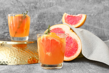 Glass of tasty grapefruit lemonade on grey background