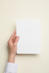 Woman holding blank sheet of paper on color background