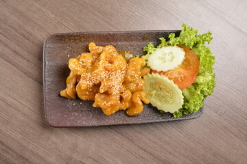 deep fried chicken with lemon sauce and sesame on wood background asian halal menu