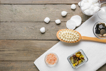 Massage brush and different bath supplies on wooden background
