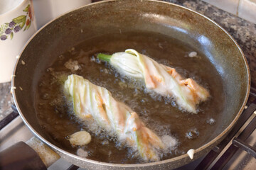  zucchini flowers during frying in pan