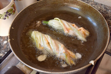  zucchini flowers during frying in pan