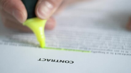 Reading a paper document "Contract", underlining, highlighting the necessary information. Blurred image.