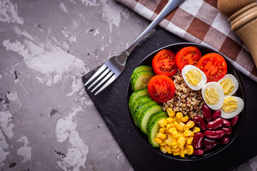 bowl of healthy quinoa with vegetables on a dark rustic background