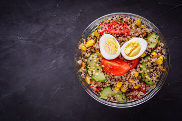 bowl of healthy quinoa with vegetables on a dark rustic background