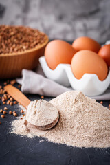 fresh natural buckwheat flour on a dark stone background culinary concept