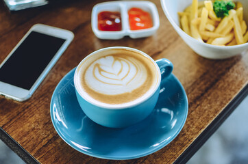 Fototapeta na wymiar blue cup cappuccino coffee on the table