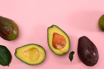 Half avocado isolated on pink background. Healthy fruits concept.