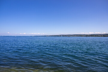 Lake Constance in Konstanz, Germany with a vibrant blue sky and hills on the far off distance