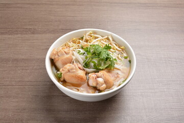 cook clear hot soup with chicken meat, vegetable  and noodle on wood background asian halal menu