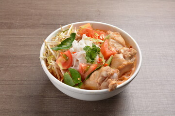 cook curry spicy chilli laksa soup with chicken meat, vegetable  and noodle on wood background asian halal menu