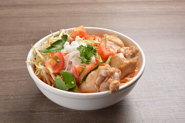 cook curry spicy chilli laksa soup with chicken meat, vegetable  and noodle on wood background asian halal menu