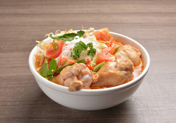 cook curry spicy chilli laksa soup with chicken meat, vegetable  and noodle on wood background...