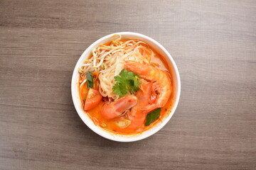 cook curry spicy chilli laksa soup with seafood prawn, vegetable  and noodle on wood background asian halal menu