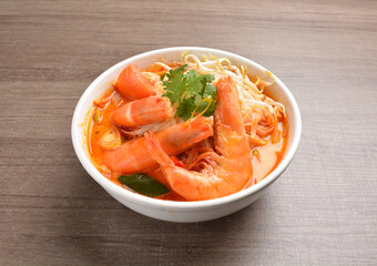 cook curry spicy chilli laksa soup with seafood prawn, vegetable  and noodle on wood background asian halal menu