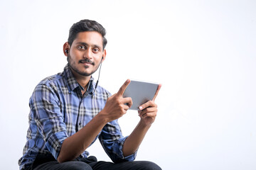 Young indian man using tablet over white background.