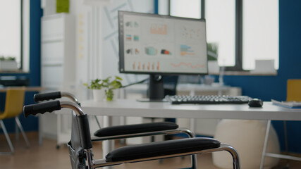 Interior of modern open plan financial office with no people, stylish room with wheelchair for invalid workers. Business center with paralized employees, shot of empty workplace, work space area