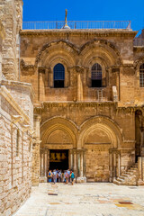 Tourists go to ?ntrance to the Church of the Holy Sepulcher on a sunny day. Jerusalem, Israel