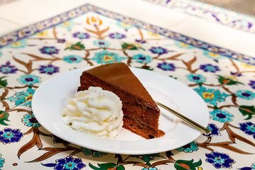 Apricot and chocolate Sacher cake with whipped cream. Sachertorte is a chocolate cake, or torte of...