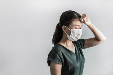 Asian Woman staff wearing face mask protection feeling sick with gray background.
