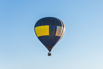 Hot Air Balloon on a blue sky.One Blue yellow hot air balloon in blue clear sky.