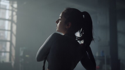 Woman in sportswear preparing body for exercising. Girl moving shoulder