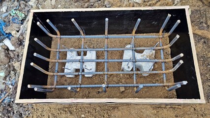 Steel grid square or iron wire column footing in shutter boards waiting for ground beam reinforced concrete work.