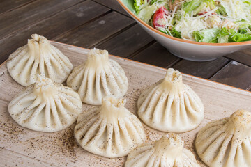 Georgian traditional food khinkali on the plate in restaurant, ready to eat, hot dish.