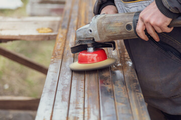A worker grinds metal at a construction site.