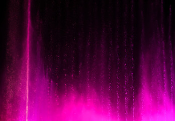 Splashing fountain in pink at night