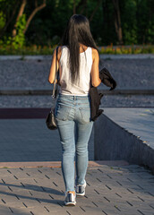 A girl with long black hair walks