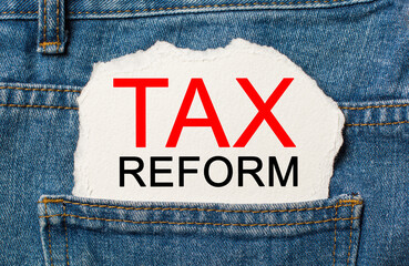 tax reform on torn paper background on jeans business and finance concept