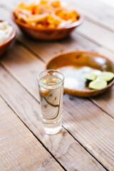 mexican tequila shot with lime and salt in a rustic table in Mexico city