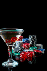 Stack of Casino gambling chips, glass of martini vermouth and red dices isolated on reflective...