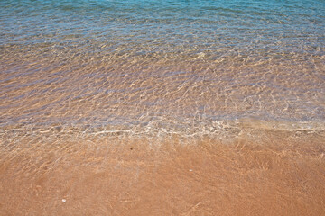 Beach with golden sand, turquoise ocean water. Panoramic sea view. Natural background for summer vacation.