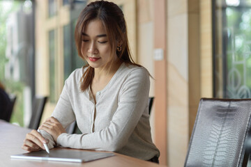 Portrait of businesswoman working on tablet and using stylus pen