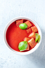 Tomato soup with basil leaves, organic vegan detox meal, overhead shot. Summer diet