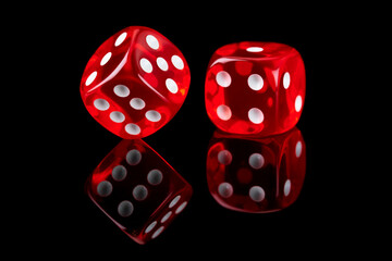 Red casino dice isolated over black reflective background