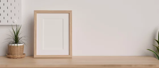 Fotobehang Per kamer Mock-up wooden frame with copy space for product display on wooden table decorated with plants and white wallpaper  © bongkarn