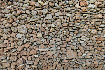 Panorama of a very old stone wall made of natural stones