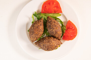 Traditional kebbe and pita bread on big round plate in lebanese restaurant. High quality photo