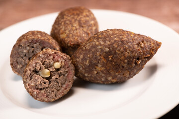 Traditional kebbe and pita bread on big round plate in lebanese restaurant. High quality photo