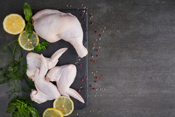 fresh chicken meat portions for cooking and barbecuing with stir fry with legs and wings with skin viewed from above with fresh seasoning,Raw chicken wings, Raw uncooked chicken leg on cutting board.